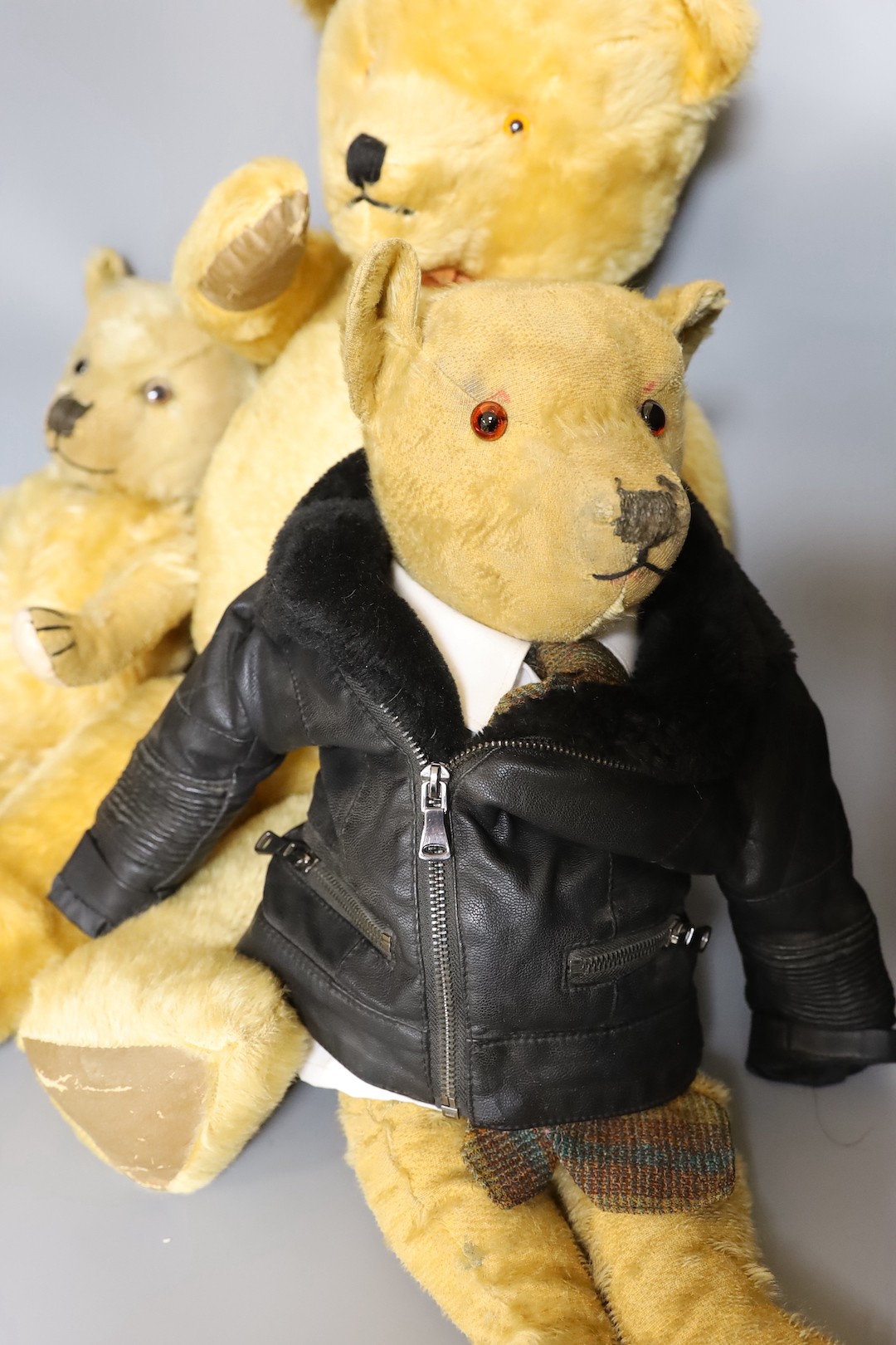 A large 1960's mohair bear, 75cm, a Chiltern 1930's bear, 50cm, and an English bear, dressed in bikers jacket and shirt, 54cm.